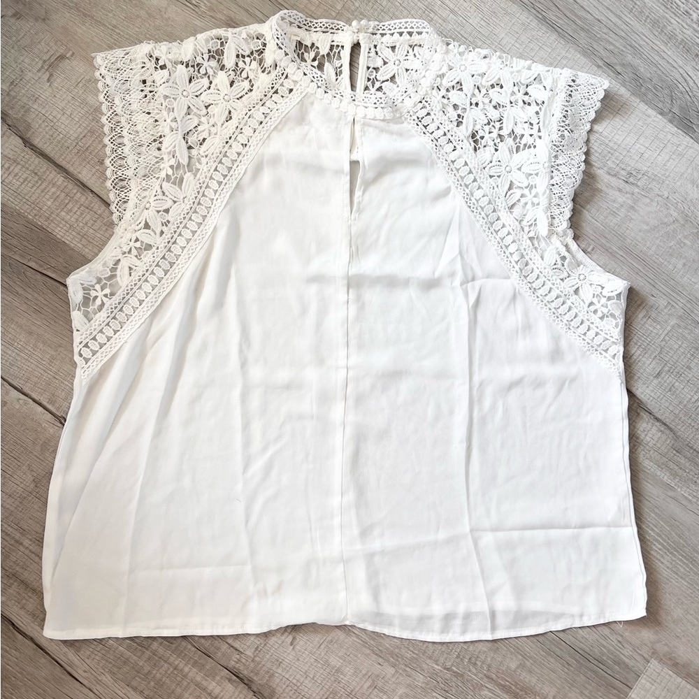 White blouse. Detailed lace trim and pearl closure.